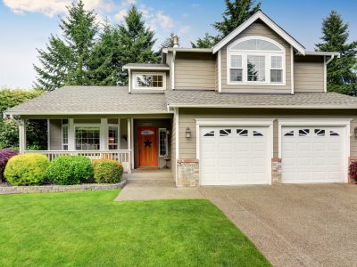 American house exterior with double garage and well kept lawn.